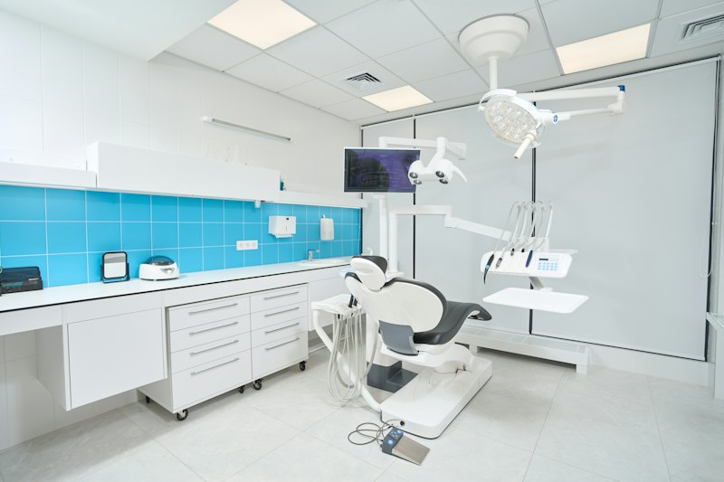 Consultorio dental luminoso con sillón y equipamiento, imagen de referencia.