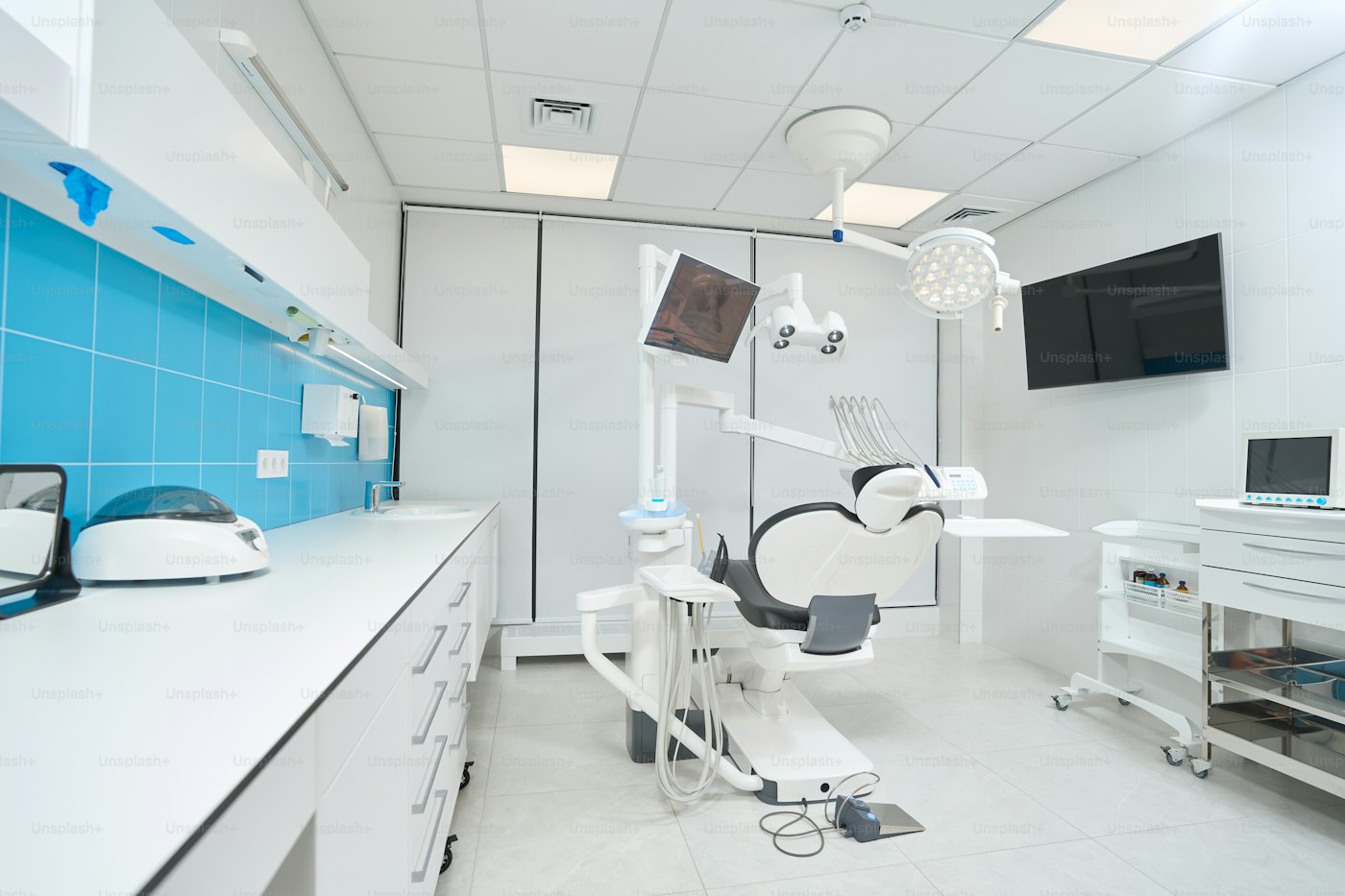 Sala de consulta dental con sillón y equipamiento, espacio luminoso de ejemplo.